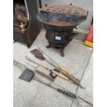 A VINTAGE CAST IRON FIRE PIT WITH AN ASSORTMENT OF GRILLING TOOLS