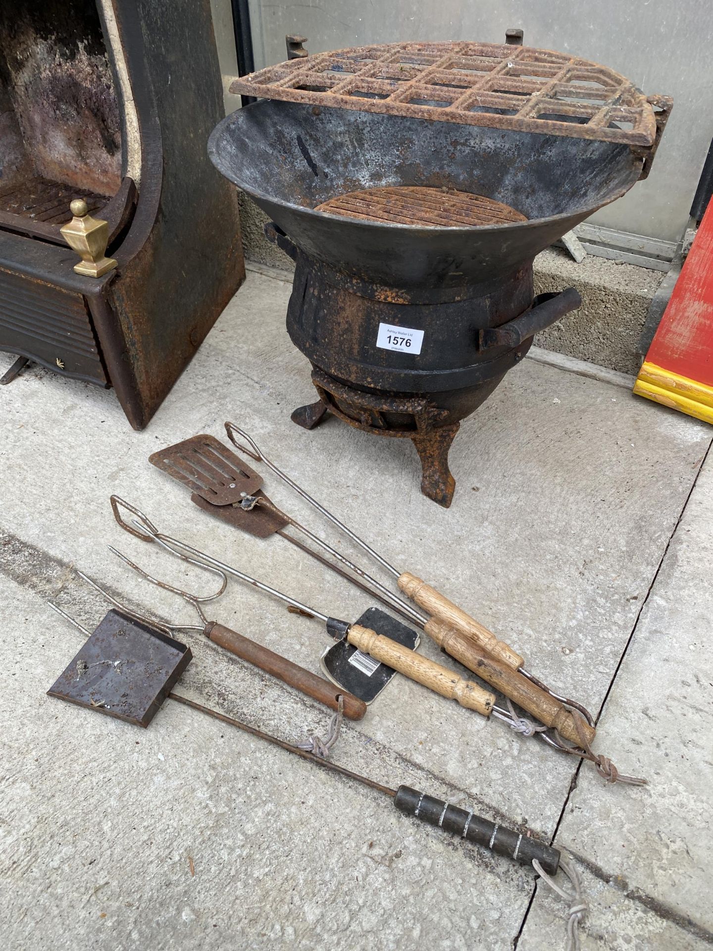 A VINTAGE CAST IRON FIRE PIT WITH AN ASSORTMENT OF GRILLING TOOLS