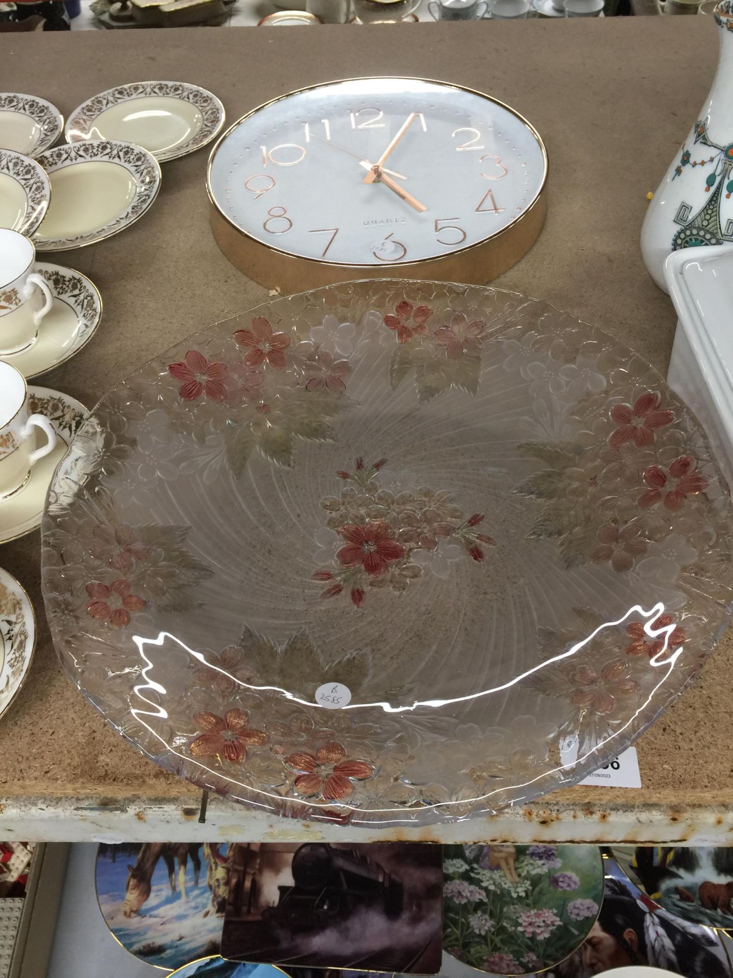 A LARGE FLORAL PATTERNED GLASS PLATE PLUS A WALL CLOCK