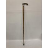 A BELIEVED SILVER TOPPED WALKING STICK WITH FLORAL CHASED AND ENGRAVED DESIGN