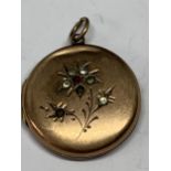 A 9 CARAT GOLD LOCKET WITH COLOURED STONE FLOWER DECORATION