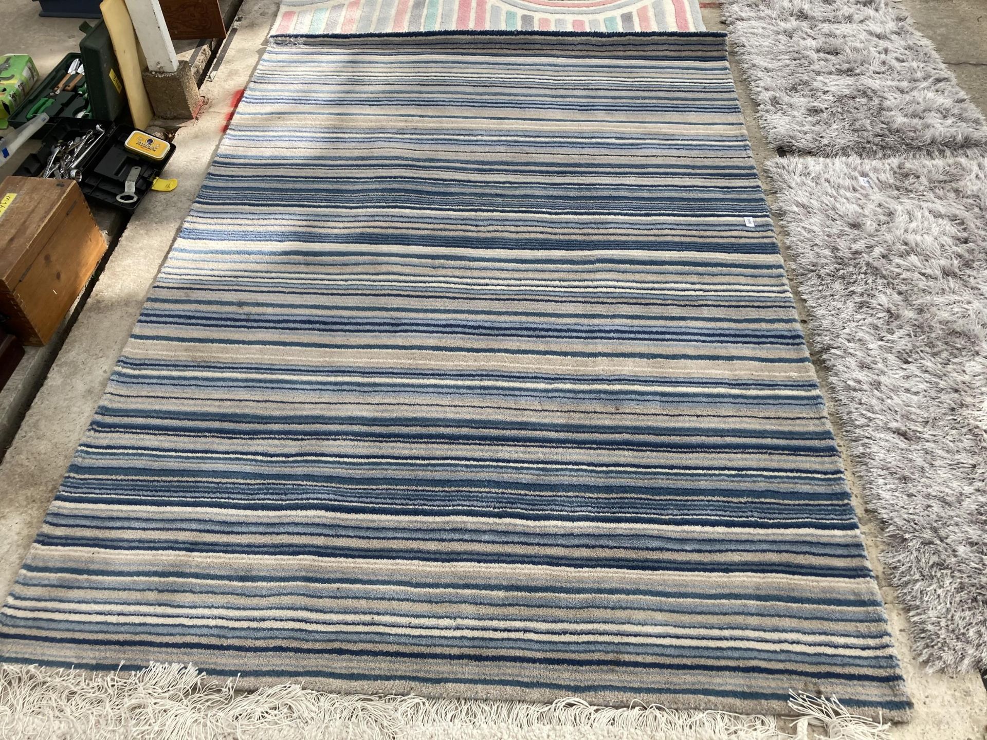 A LARGE BLUE STRIPPED RUG