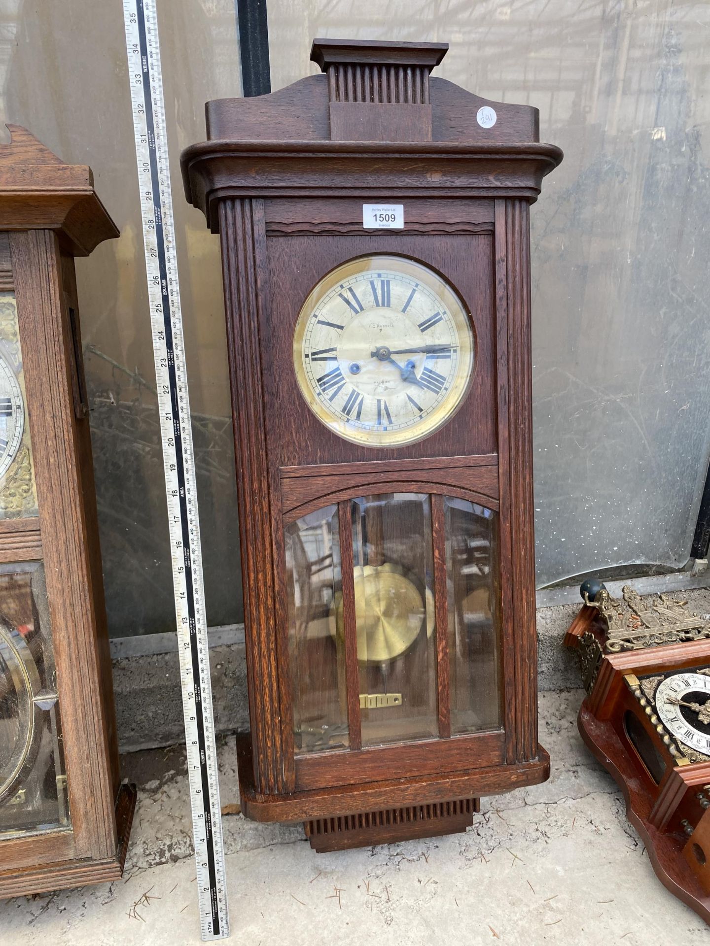 A VINTAGE OAK CASED 'F G RUSSELL' CHIMING WALL CLOCK