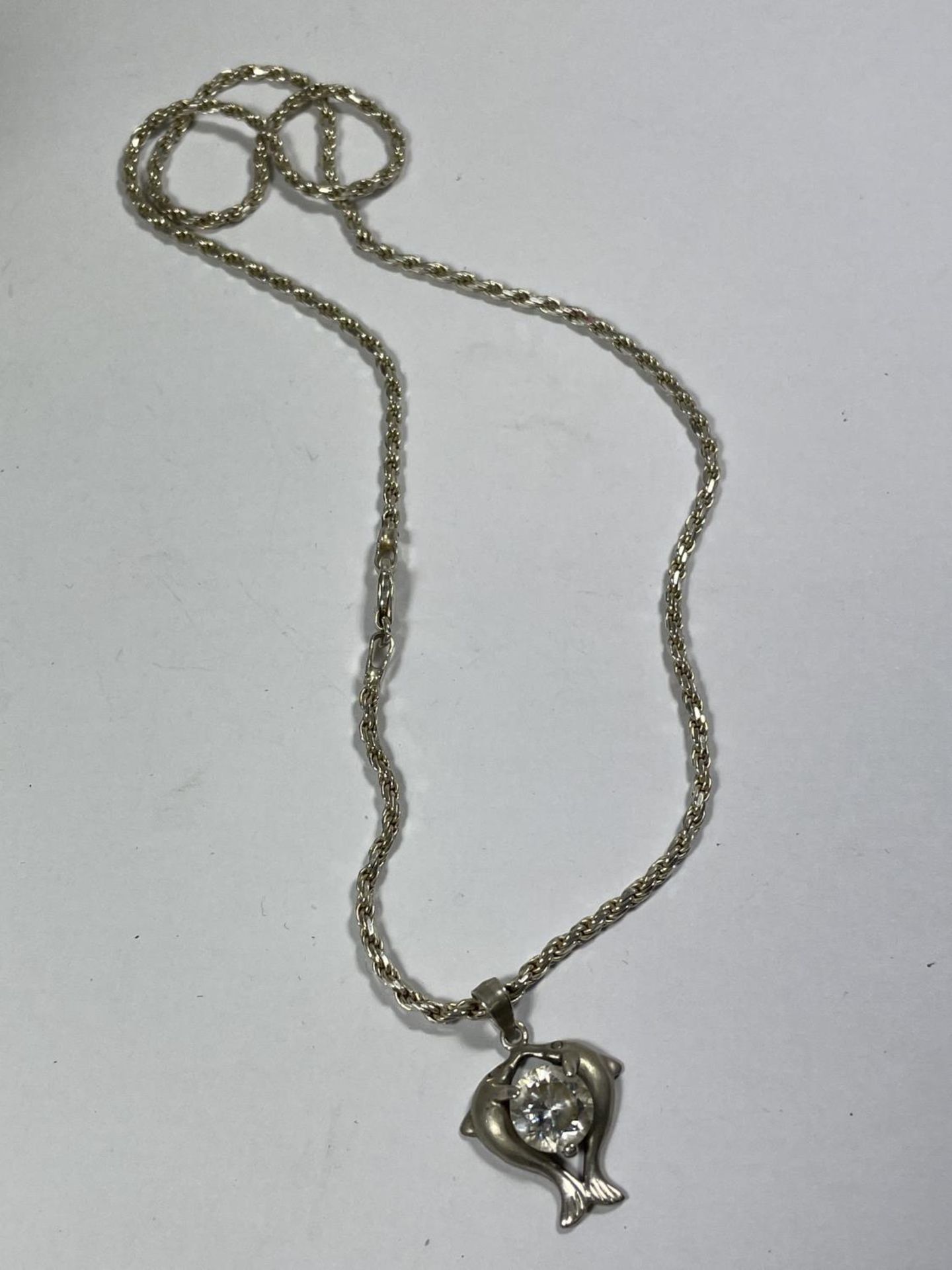 A SILVER NECKLACE WITH A DOUBLE DOLPHIN AND CLEAR STONE PENDANT AND A DOUBLE DOLPHIN RING IN A - Image 2 of 5