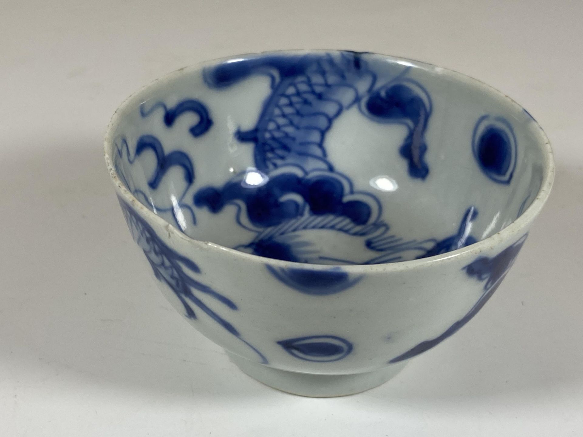 A 19TH CENTURY CHINESE BLUE AND WHITE PORCELAIN DRAGON CROSSING THE WALL DESIGN BOWL, MARKED TO - Image 4 of 9