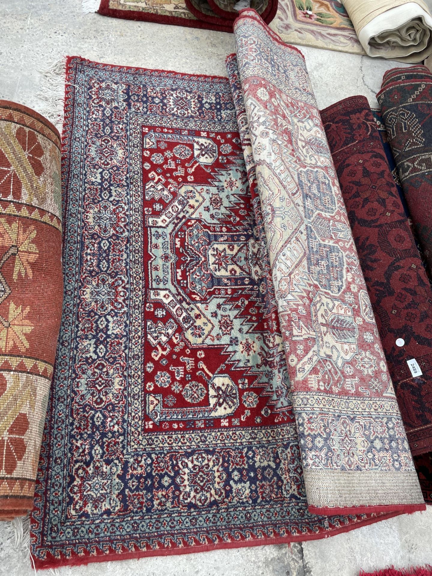 A RED PATTERNED FRINGED RUG