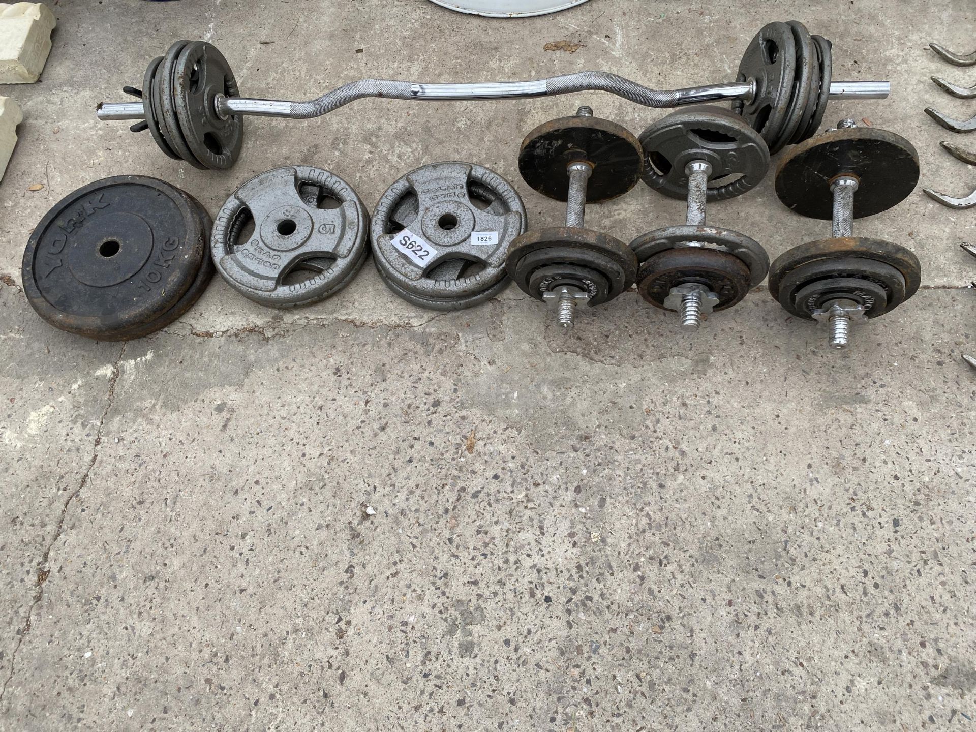 A WEIGHT LIFTING BAR, DUMB BELLS AND AN ASSORTMENT OF WEIGTHS