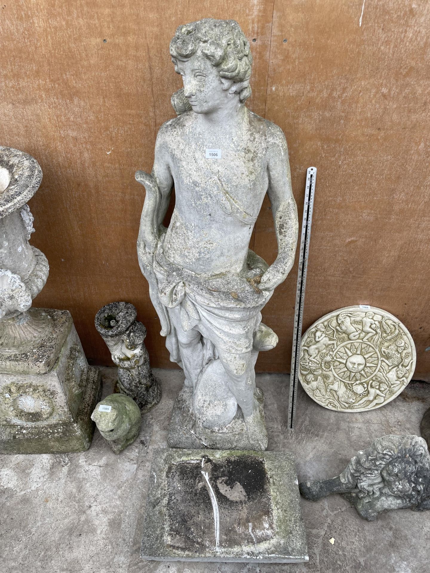 A LARGE RECONSTITUTED STONE CHERUB GARDEN FIGURE WITH PLINTH BASE (H:147CM WITH PLINTH) (A/F)