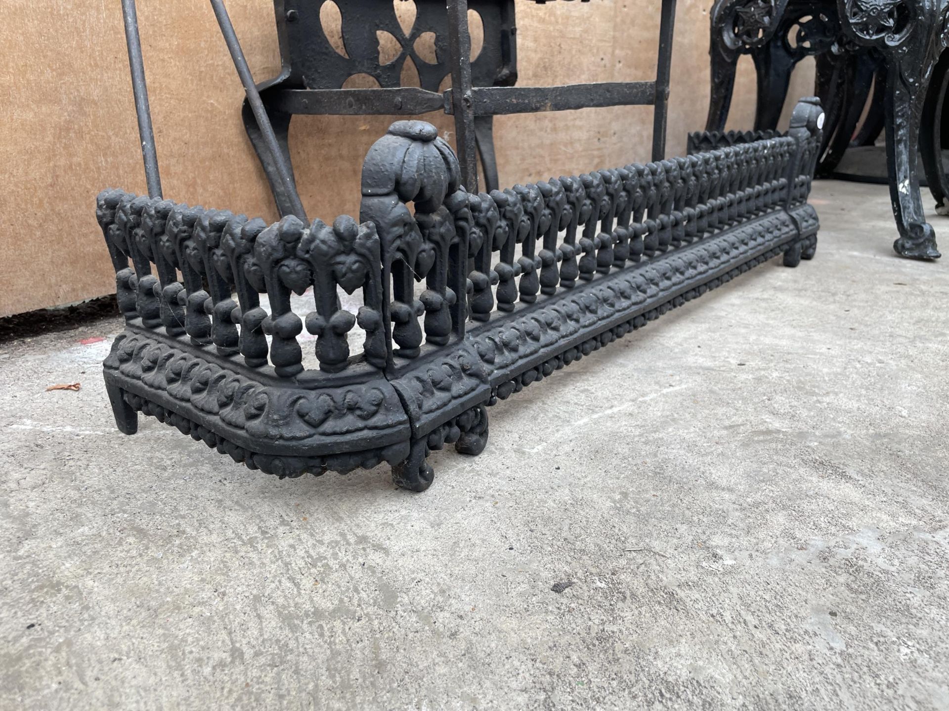 A DECORATIVE CAST IRON FIRE FENDER, A WROUGH IRON TRIVET STAND AND A PAIR OF FIRE TONGS - Image 3 of 3