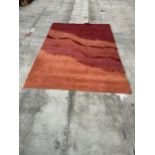 A NEPALESE HAND WOVEN PURE WOOL RUG, MULTI-COLOURED, BASE RED - 241 CM X 171 CM