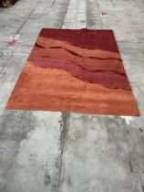 A NEPALESE HAND WOVEN PURE WOOL RUG, MULTI-COLOURED, BASE RED - 241 CM X 171 CM