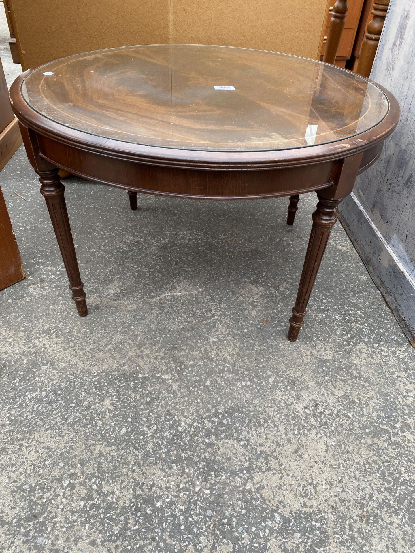 A MAHOGANY COFFEE TABLE, 29" DIAMETER, ON TURNED AND FLUTED LEGS