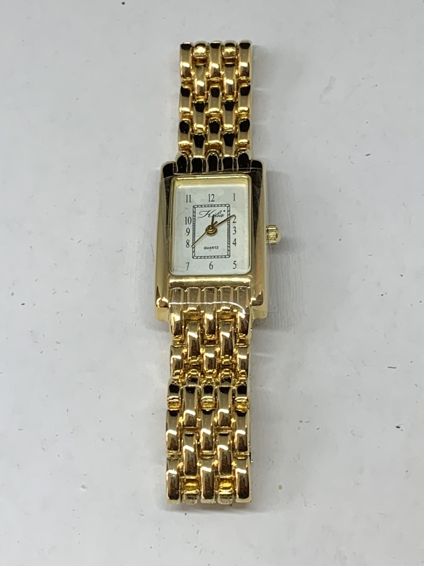 A YELLOW METAL WRIST WATCH WITH RECTANGULAR FACE SEEN WORKING BUT NO WARRANTY