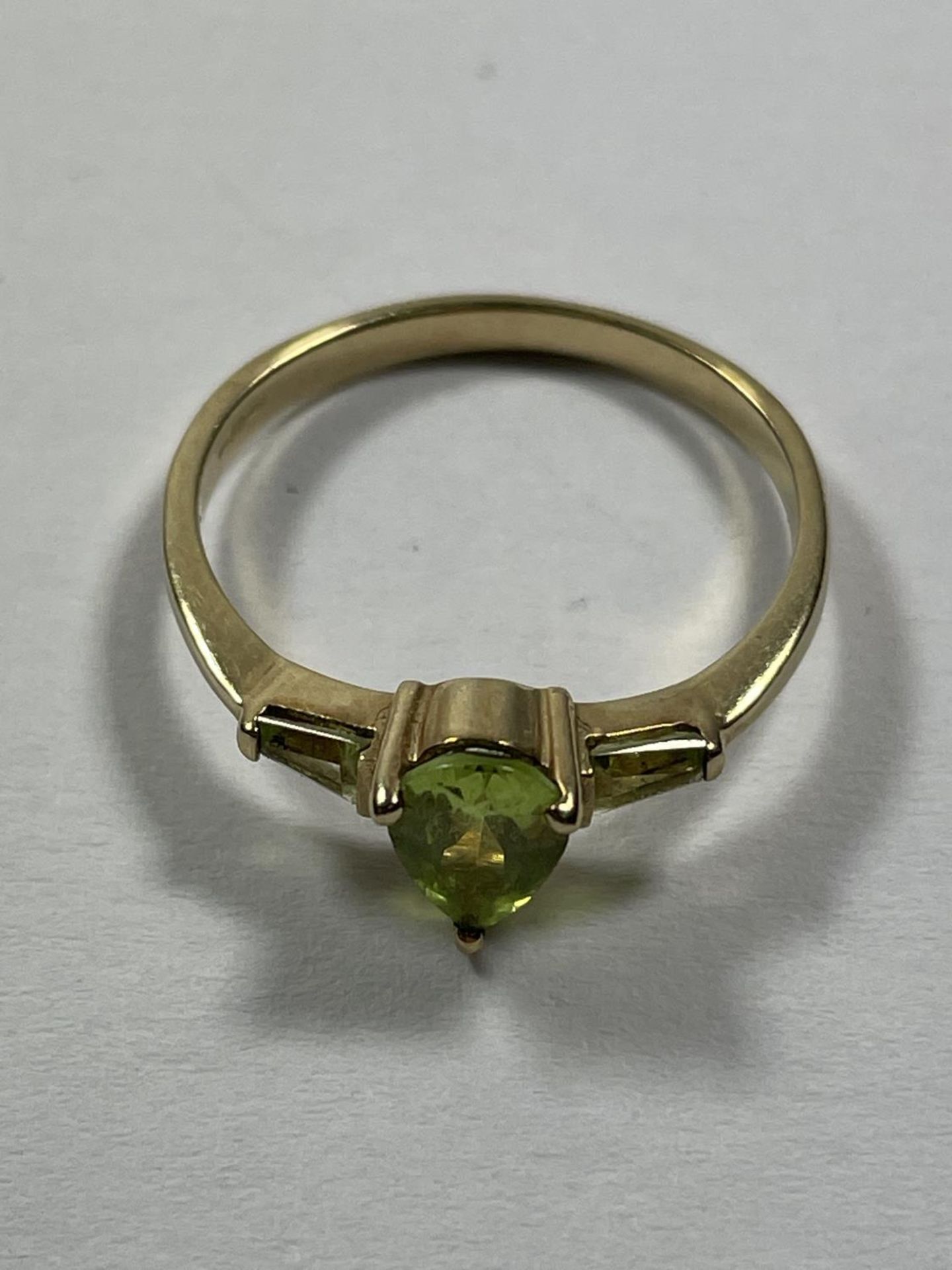 A 9 CARAT GOLD RING WITH A TEARDROP PERIDOT STONE AND ONE TO EACH SHOULDER SIZE P - Image 3 of 3