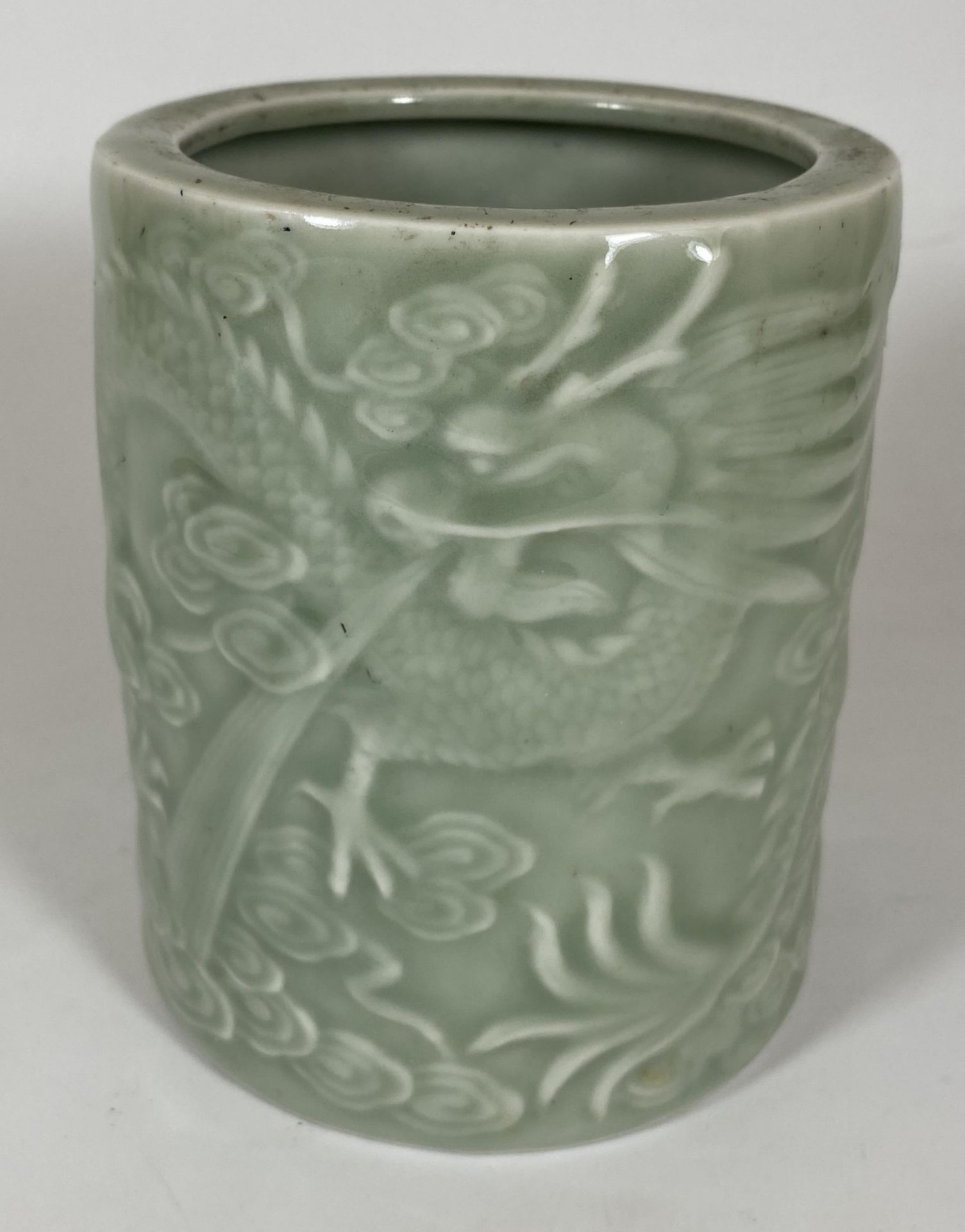 A CHINESE CELADON PORCELAIN BRUSH POT WITH DRAGON AMONGST THE CLOUDS DESIGN, HEIGHT 12.5CM