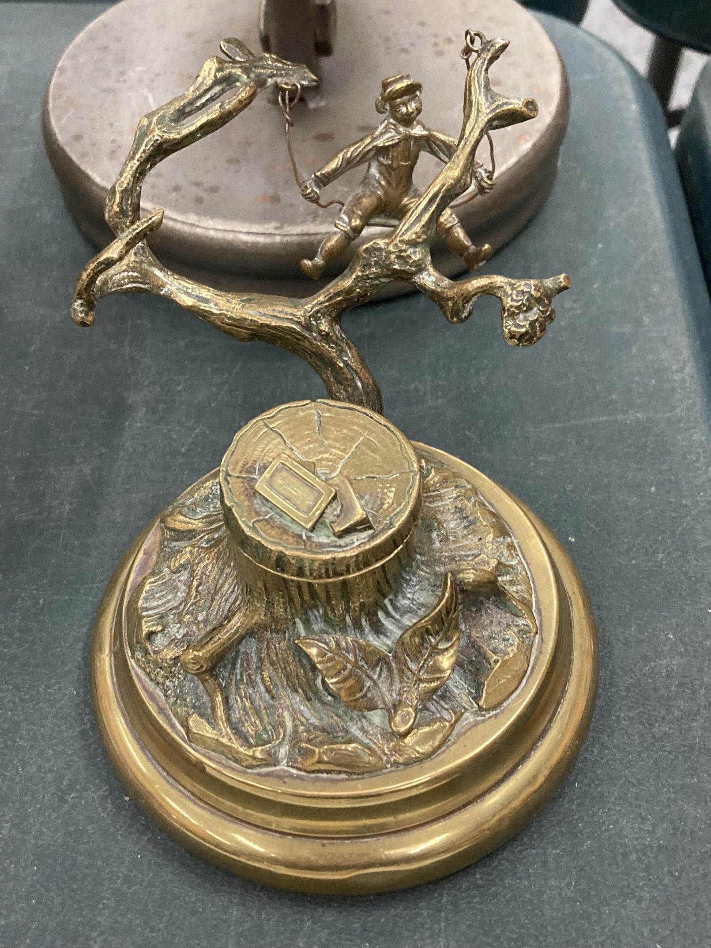 A VINTAGE NOVELTY BRASS INKWELL WITH A SINGING BOY IN A TREE