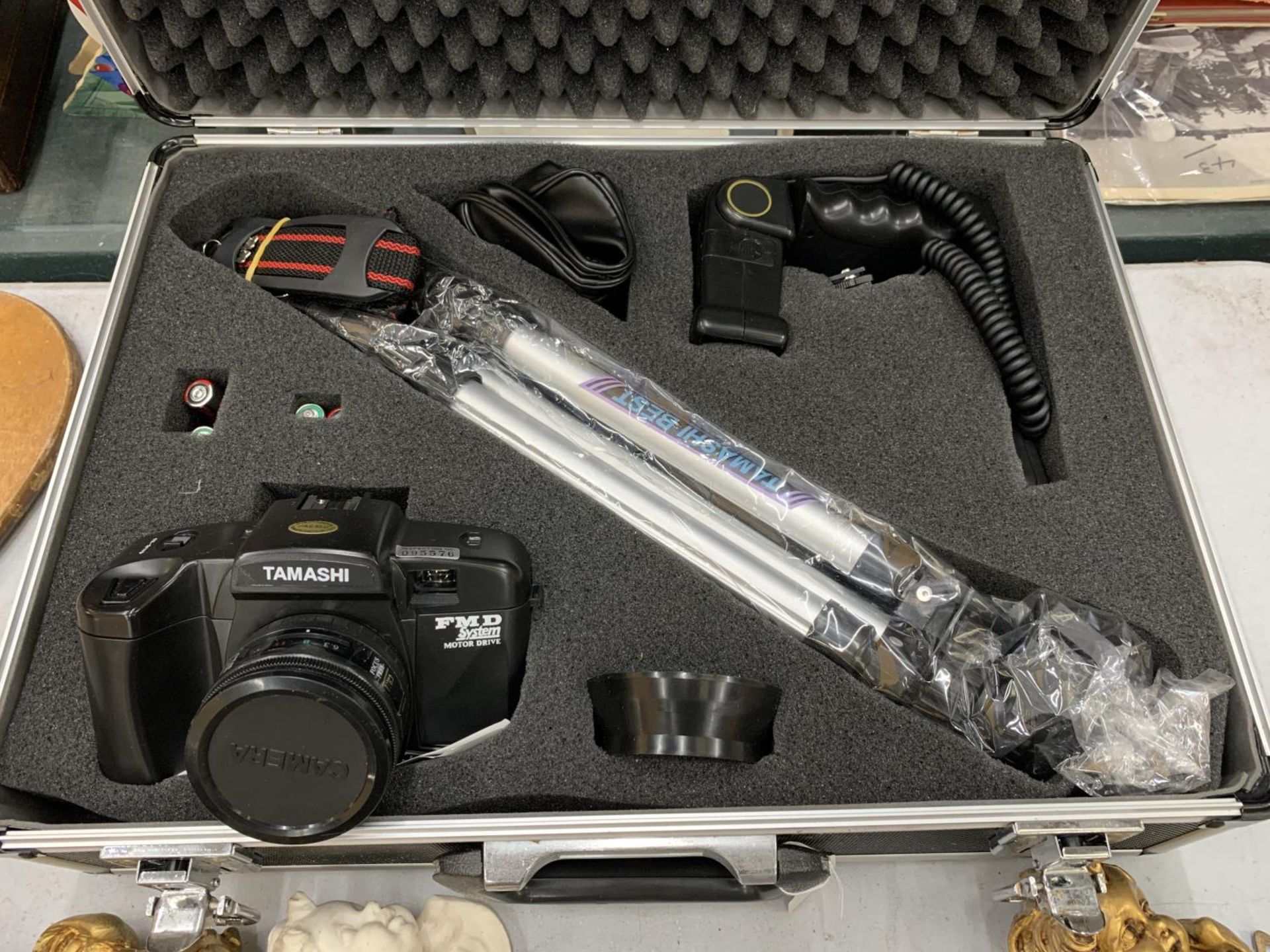 A TAMASHI FMD SYSTEM MOTOR DRIVE CAMERA, BAG, FLASH, AND STRAP IN A METAL CASE