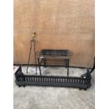 A DECORATIVE CAST IRON FIRE FENDER, A WROUGH IRON TRIVET STAND AND A PAIR OF FIRE TONGS