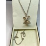 A SILVER TEDDY BEAR NECKLACE IN A PRESENTATION BOX