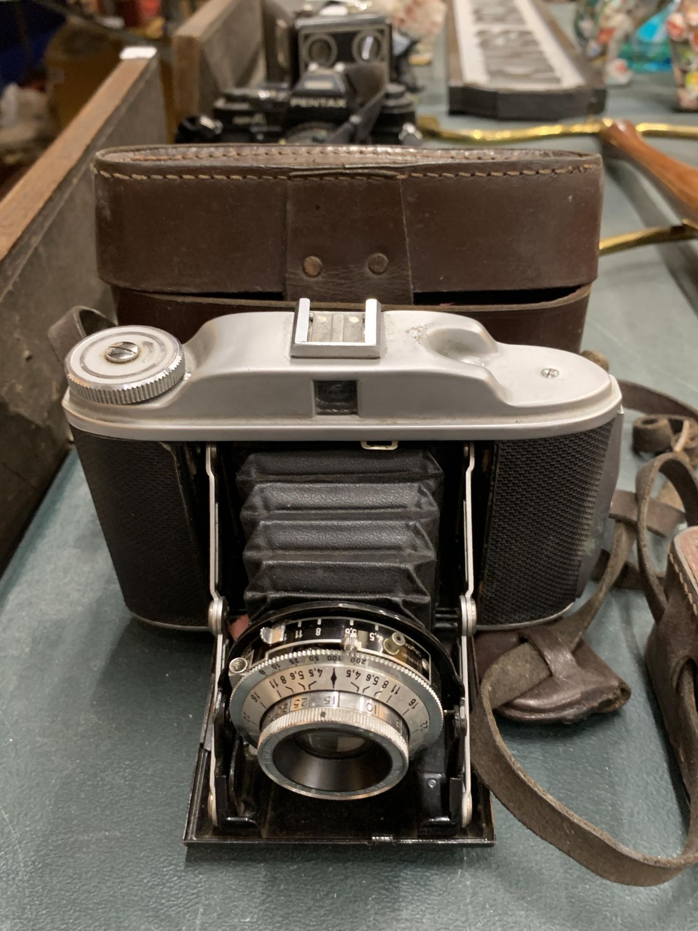 A VINTAGE VELIO BELLOWS CAMERA WITH LEATHER CASE