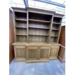 A MODERN BREAKFRONT OAK OPEN BOOKCASE WITH FOUR CUPBOARDS TO THE BASE, 79" WIDE, 21" DEEP AND 80"