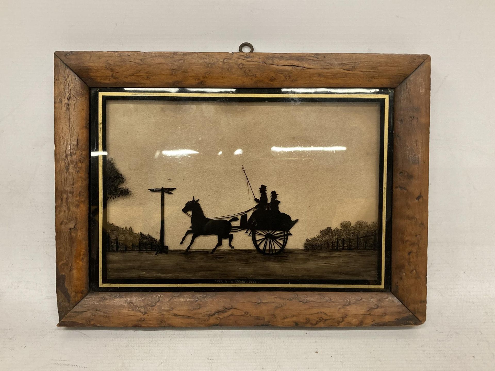 A FRAMED SILHOUETTE GLASS SLIDE TITLED 'OFF TO THE DERBY'