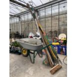 AN ASSORTMENT OF GARDEN ITEMS TO INCLUDE A WHEEL BARROW, RAKES AND BRUSHES ETC