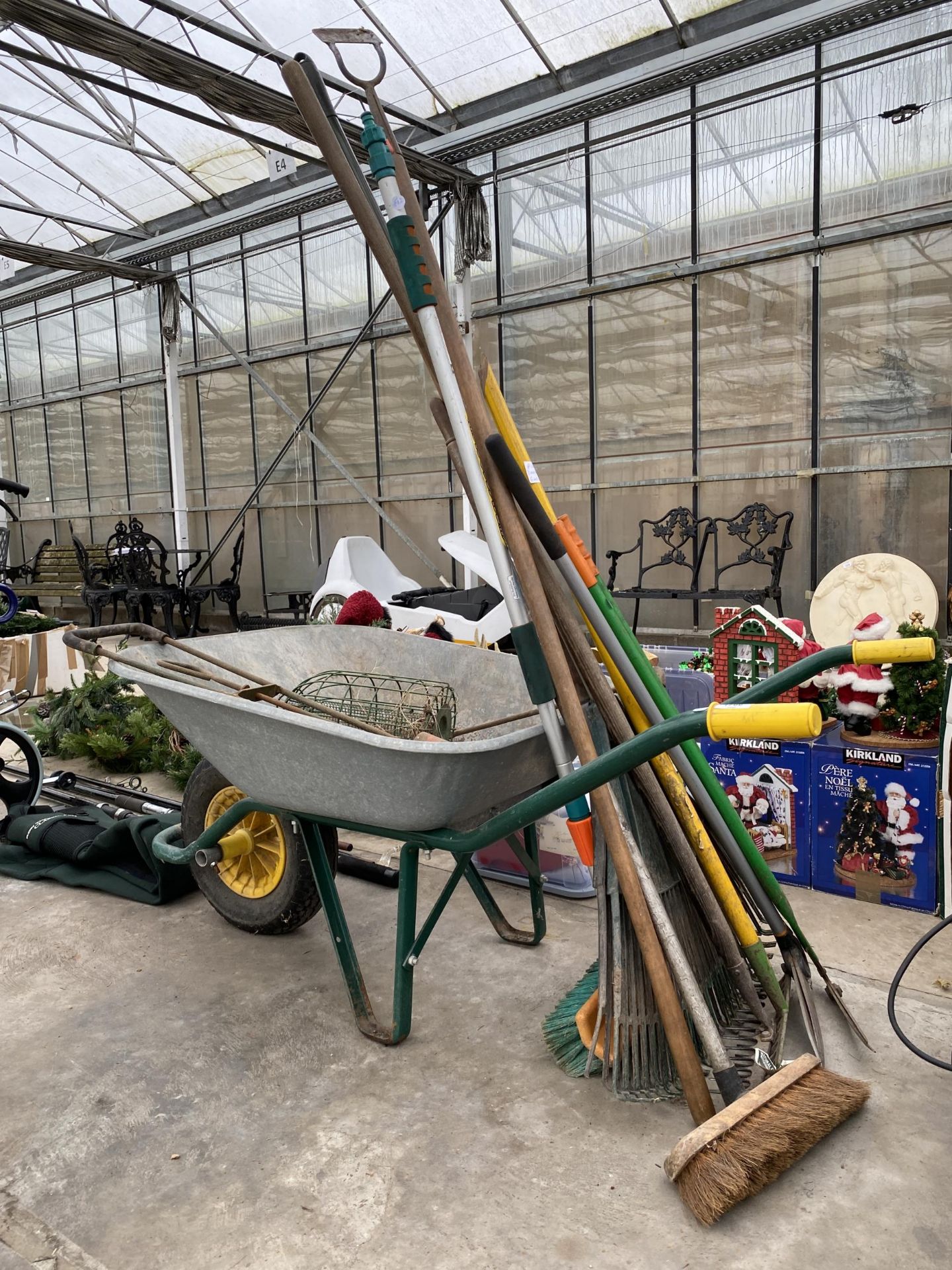 AN ASSORTMENT OF GARDEN ITEMS TO INCLUDE A WHEEL BARROW, RAKES AND BRUSHES ETC