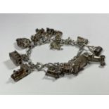 A HEAVY SILVER CHARM BRACELET WITH FOURTEEN CHARMS