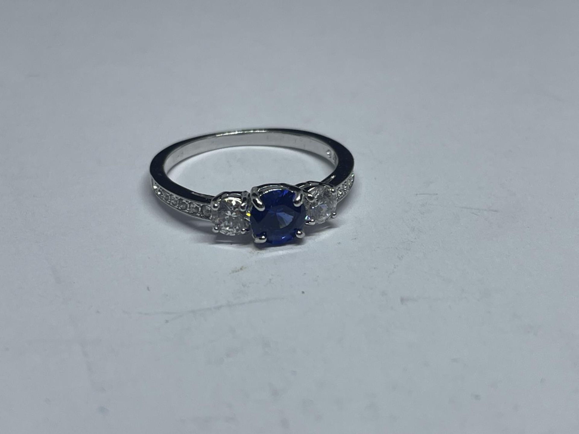 A SWAROVSKI RING WITH BLUE AND CLEAR CRYSTALS WITH LABEL, PRESENTATION BOX AND SLEEVE SIZE K/L