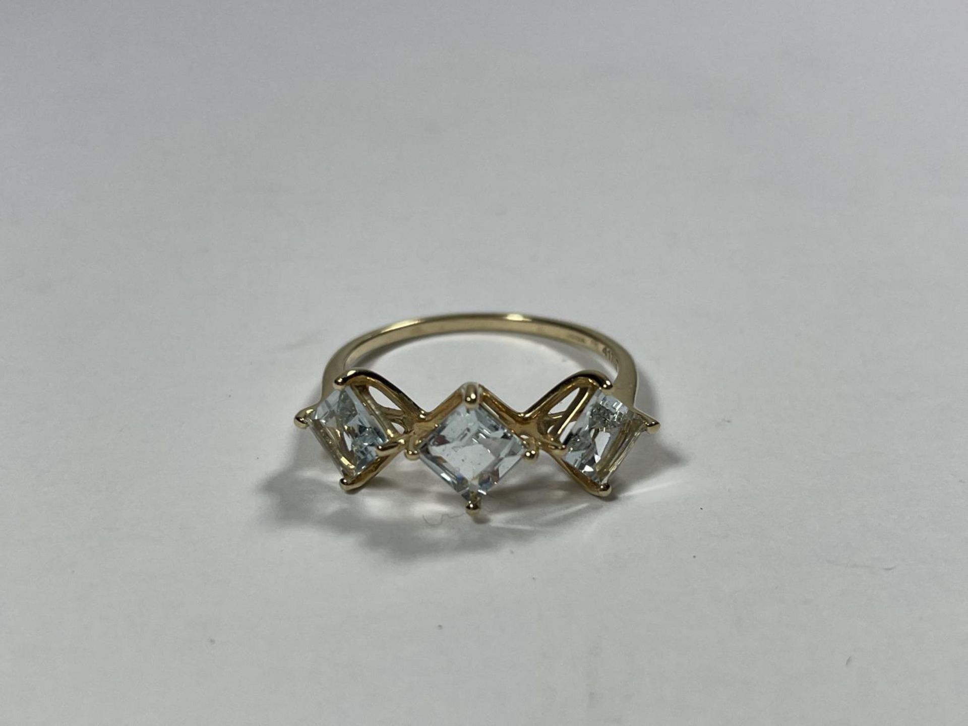 A 10 CARAT GOLD RING WITH THREE IN LINE DIAMOND SHAPED STONES SIZE S