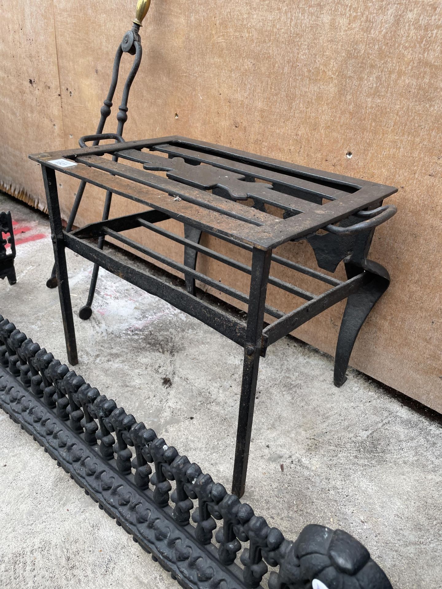 A DECORATIVE CAST IRON FIRE FENDER, A WROUGH IRON TRIVET STAND AND A PAIR OF FIRE TONGS - Image 2 of 3