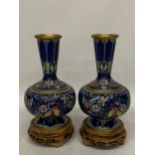 A PAIR OF CHINESE CLOISONNE VASES WITH BUTTERFLY DECORATION ON CARVED WOODEN STANDS