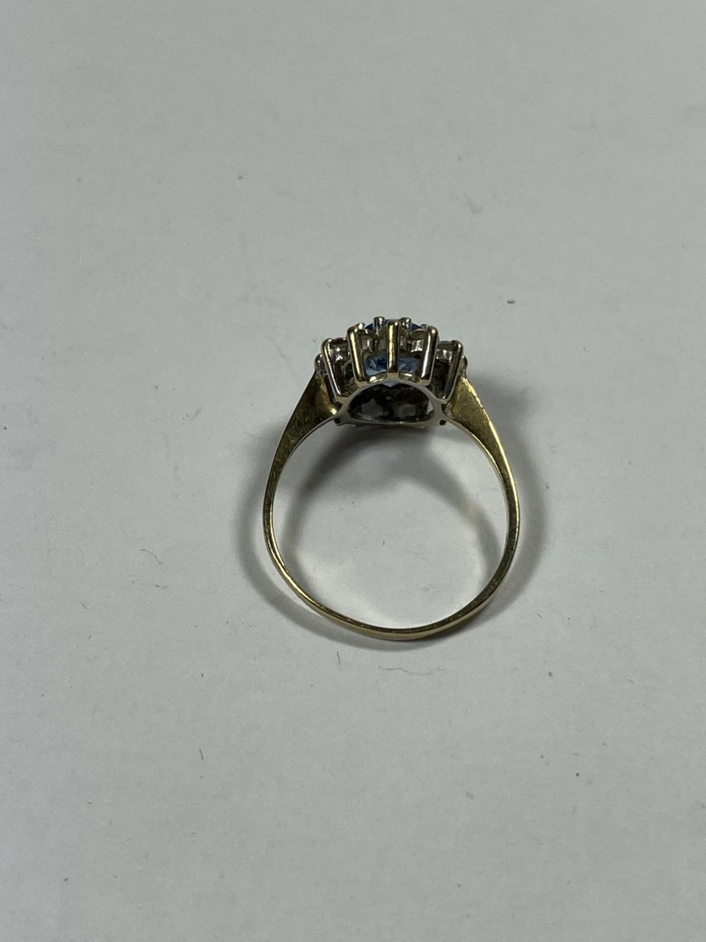 A 9 CARAT GOLD RING WITH A CENTRE TOPAZ SURROUNDED BY TWELVE CUBIC ZIRCONIAS SIZE N/O - Bild 2 aus 3