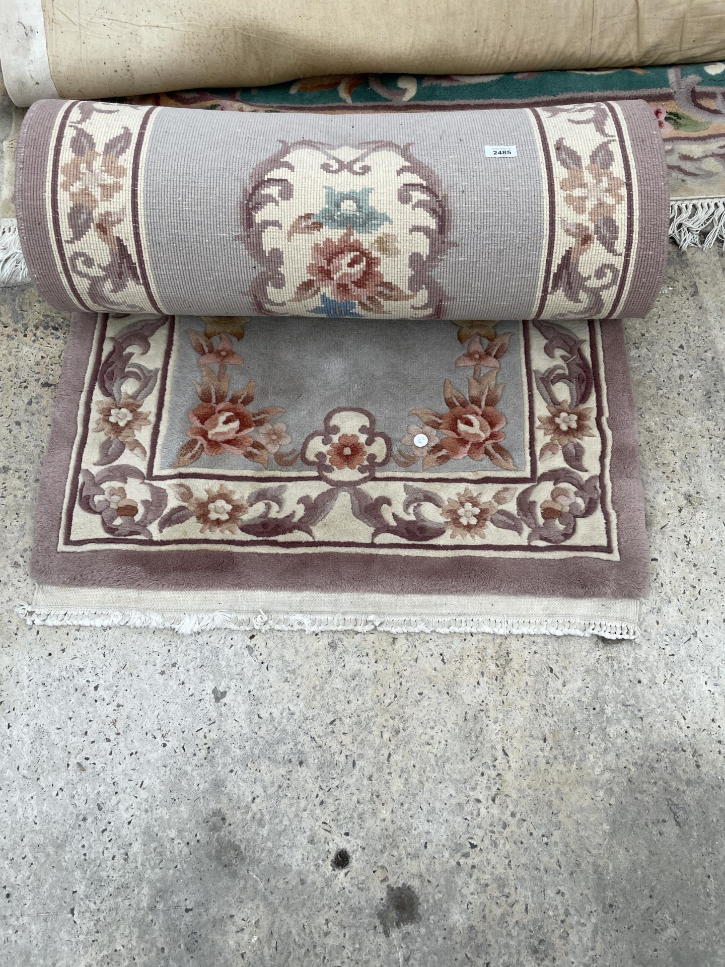 A SMALL PURPLE PATTERNED FRINGED CARPET RUNNER