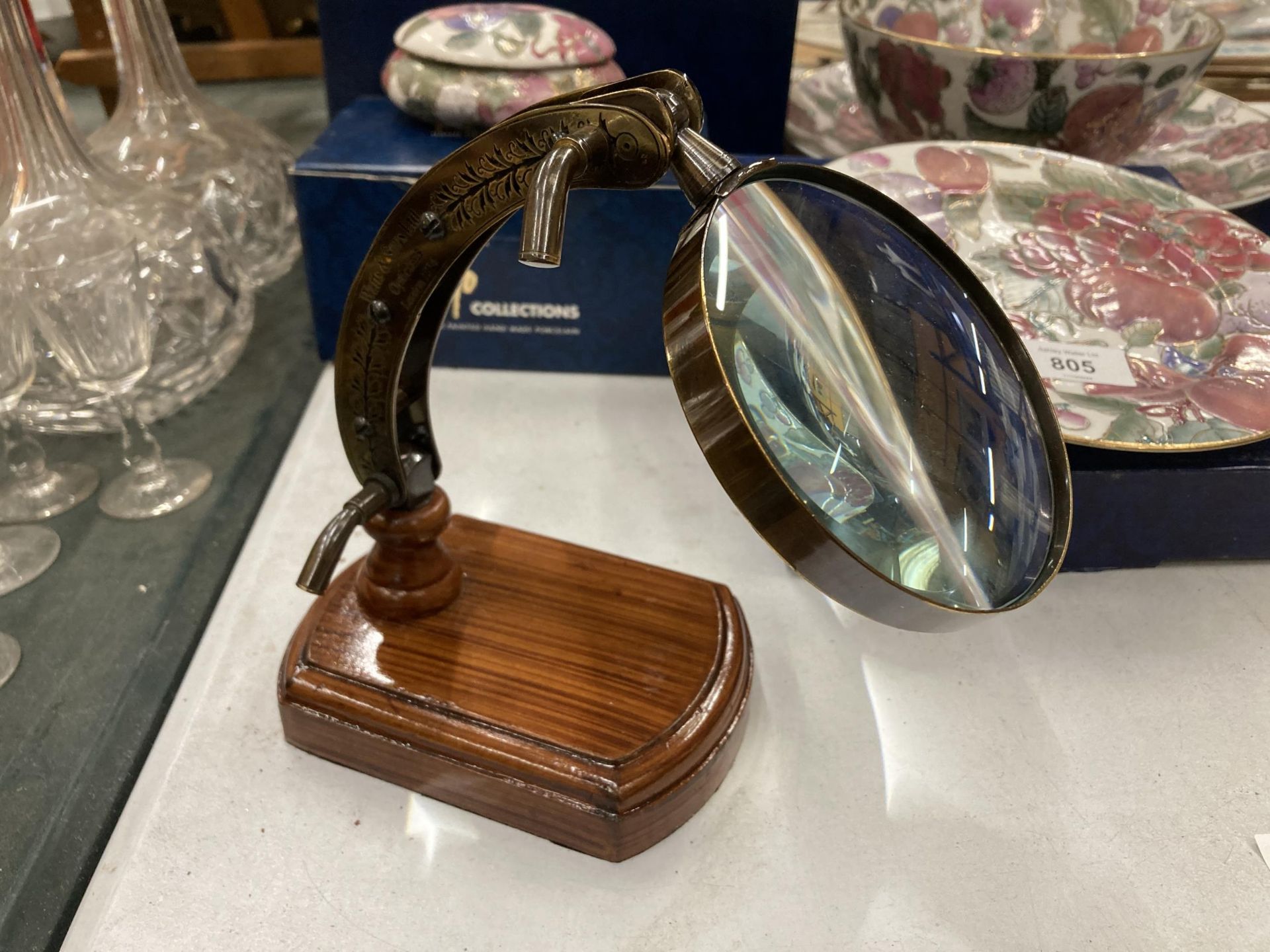 A TABLE TOP MAGNIFYING GLASS ON A WOODEN PLINTH, HEIGHT 18CM