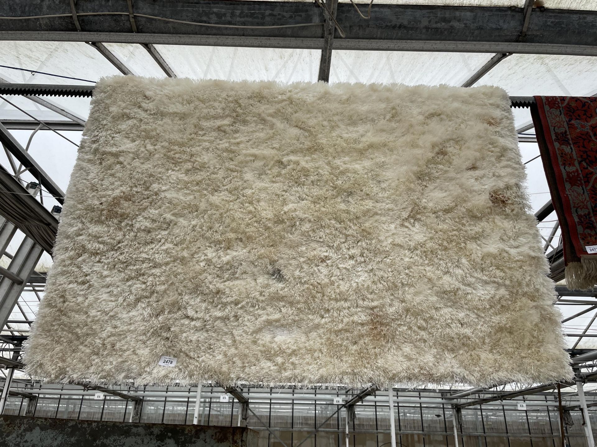 A MODERN CREAM SHAGGY RUG