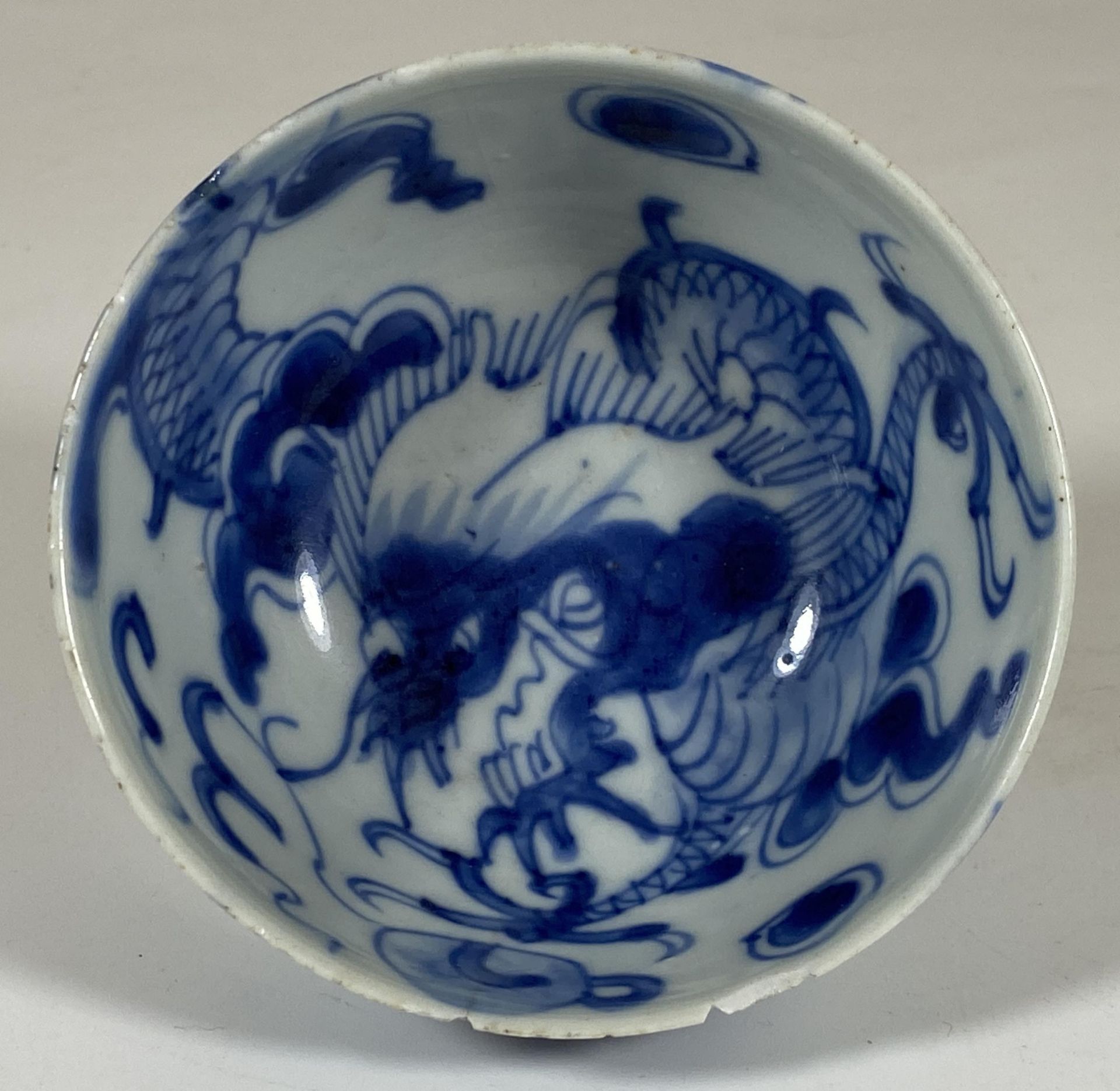 A 19TH CENTURY CHINESE BLUE AND WHITE PORCELAIN DRAGON CROSSING THE WALL DESIGN BOWL, MARKED TO