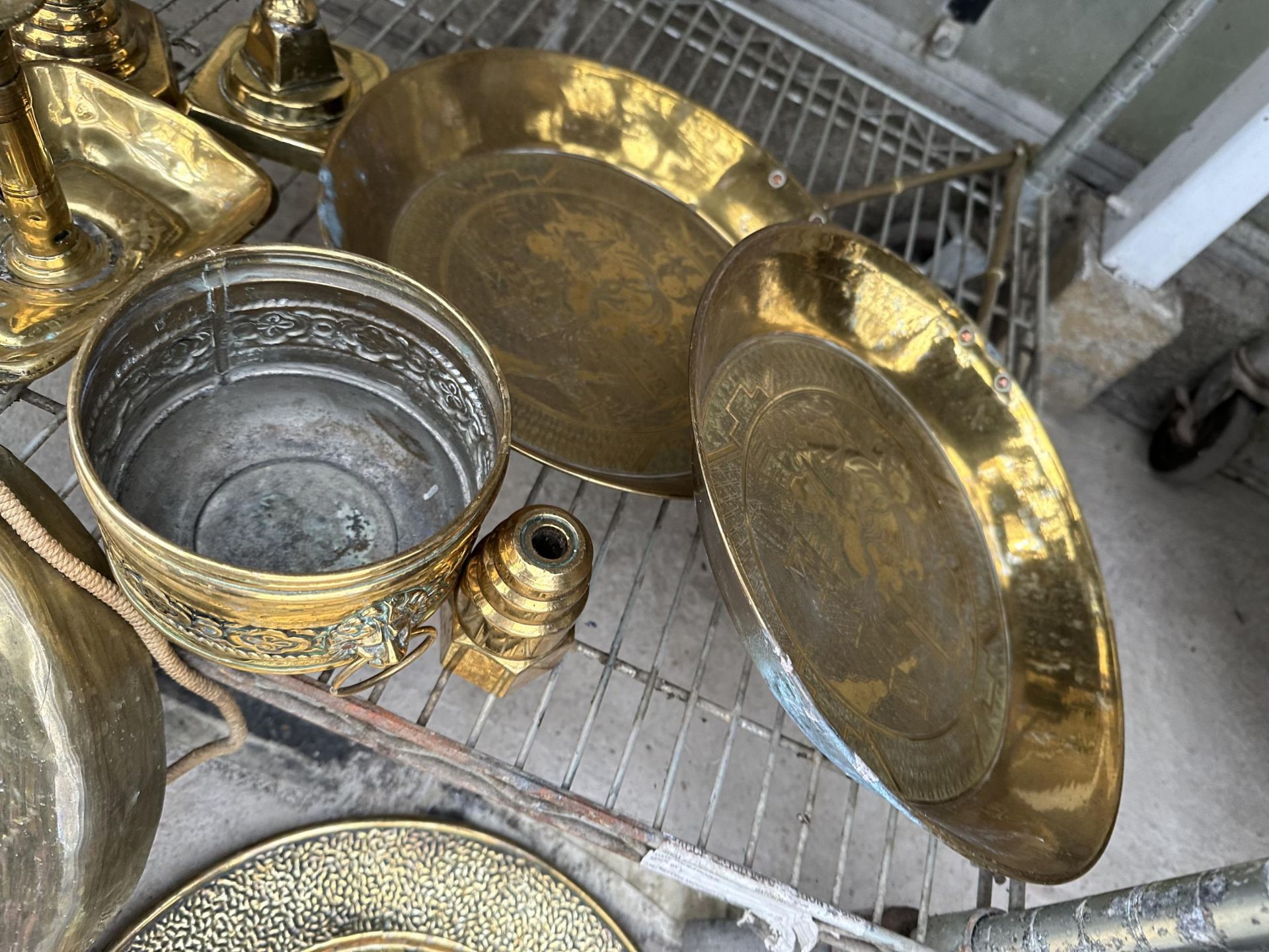 A LARGE ASSORTMENT OF BRASS ITEMS TO INCLUDE PANS, CHARGERS,A GONG AND CANDLE STICKS ETC - Image 3 of 4