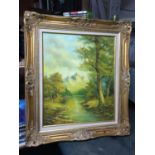 A GILT FRAMED OIL ON CANVAS PAINTING OF A BOY BY A WOODLAND STREAM WITH MOUNTAINS IN THE DISTANCE,