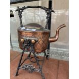 A VINTAGE COPPER KETTLE WITH A CAST CANDLE HOLDER STAND