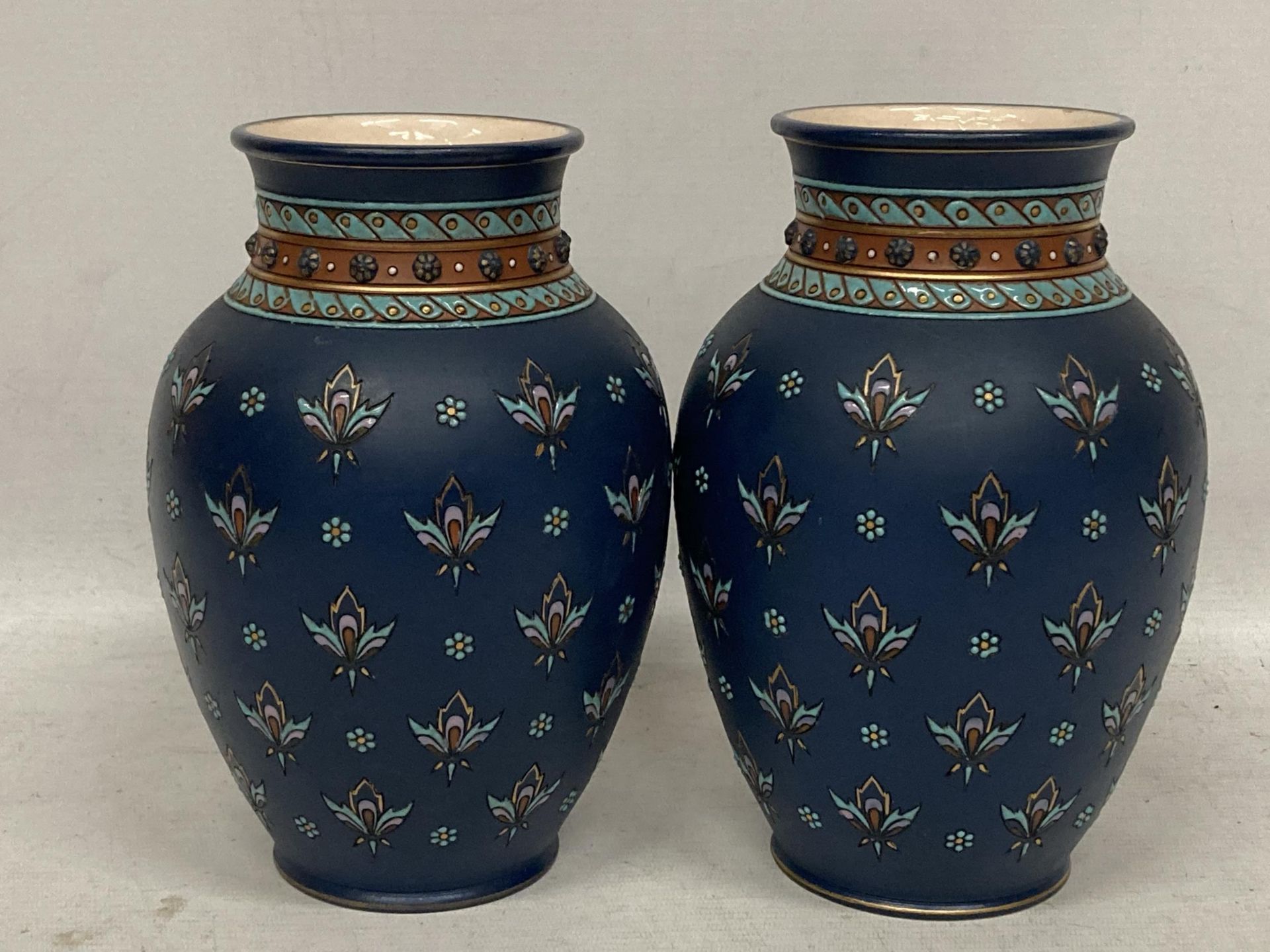 A PAIR OF METTLACH FLORAL DESIGN VASES, STAMPED 1875 TO BASE