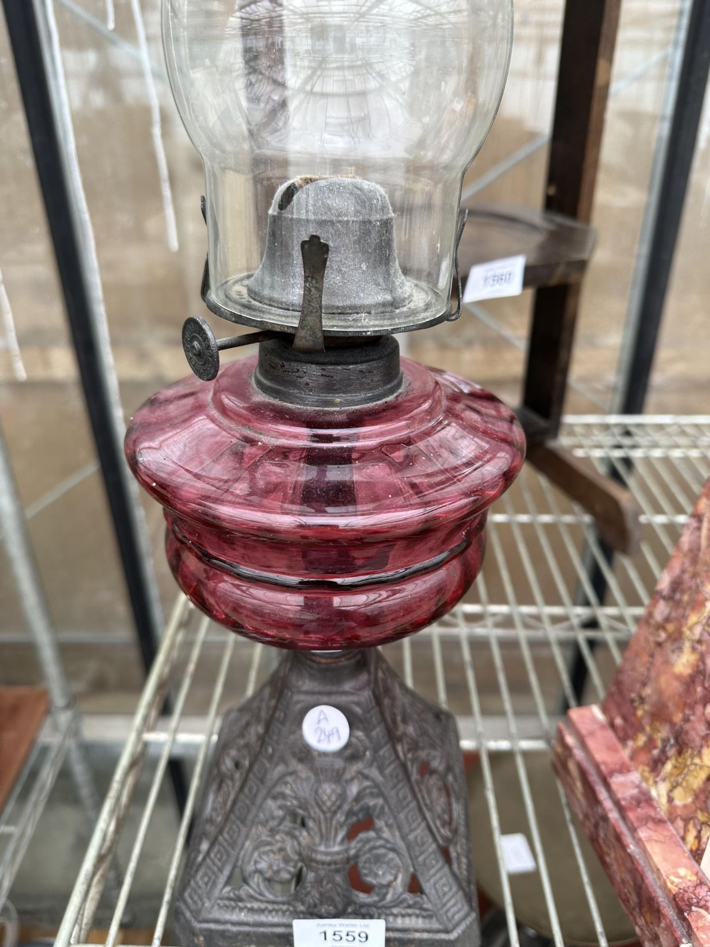 A CAST IRON AND CRANBERRY GLASS OIL LAMP - Image 2 of 2
