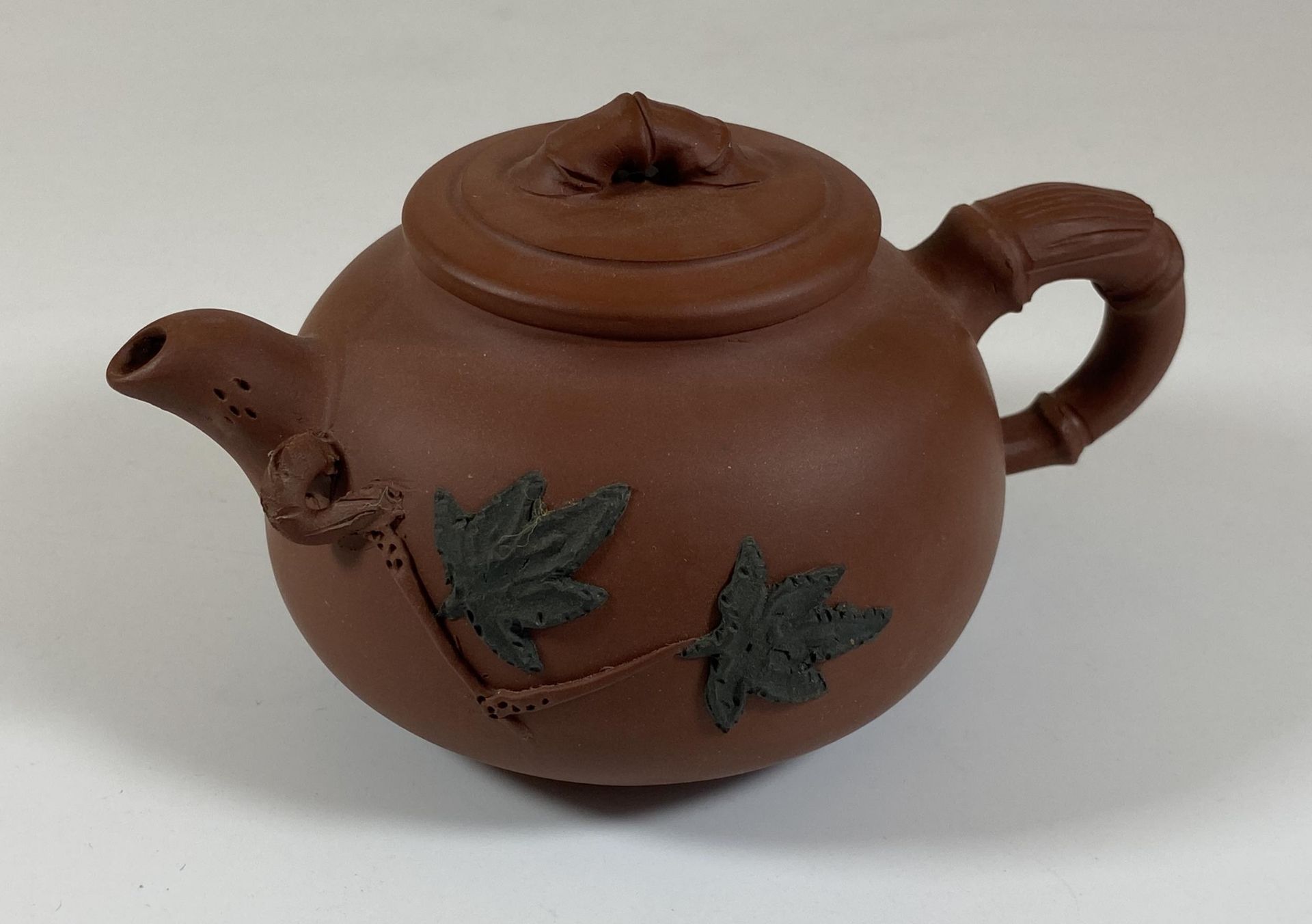 A CHINESE YIXING CLAY TEAPOT WITH FLORAL RELIEF MOULDED DESIGN, SEAL MARK TO BASE AND LID INNER,