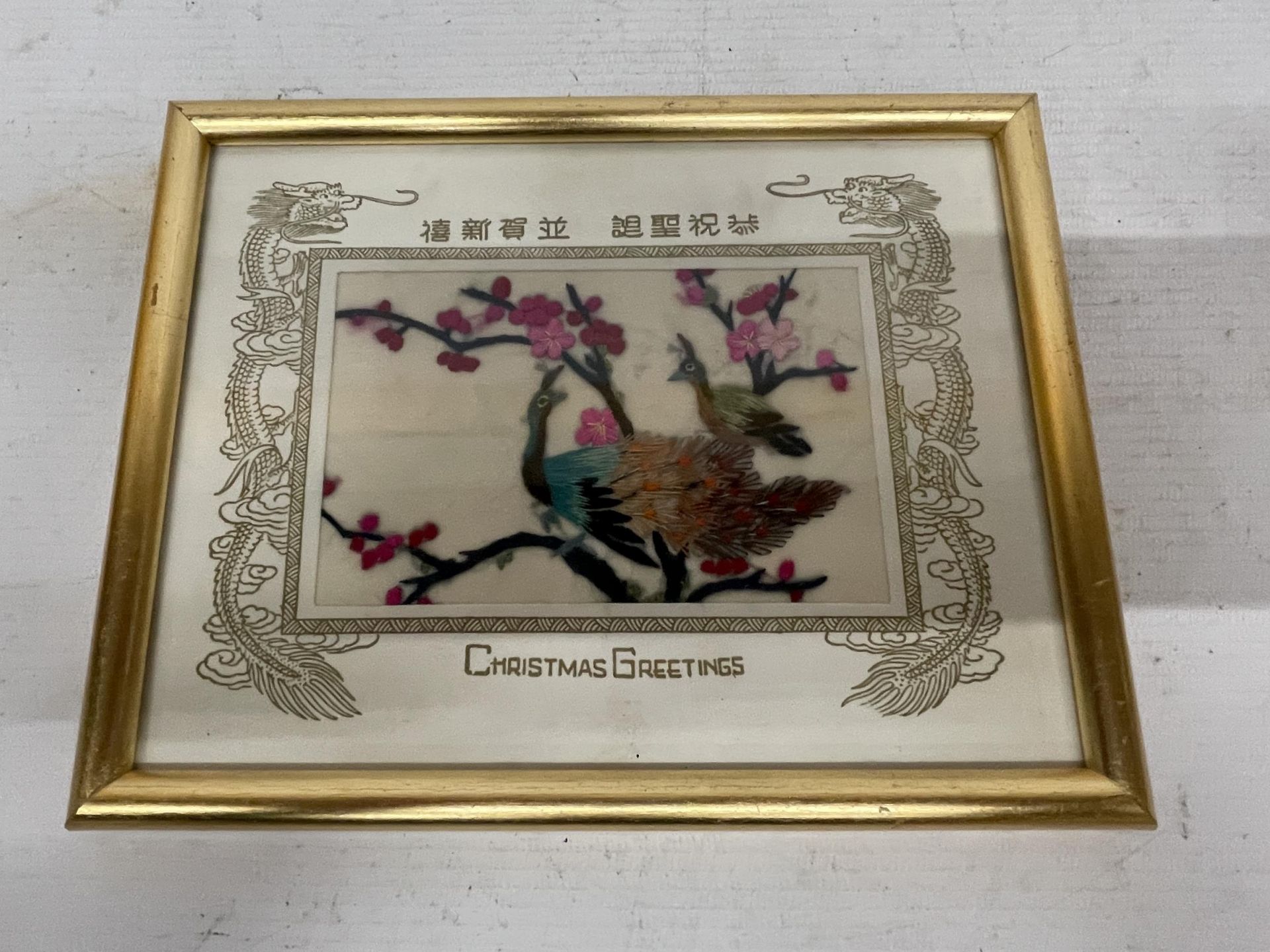 A GILT FRAMED ORIENTAL CHRISTMAS GREETINGS EMBROIDERED PICTURE