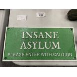 A CAST INSANE ASYLUM PLEASE ENTER WITH CAUTION SIGN