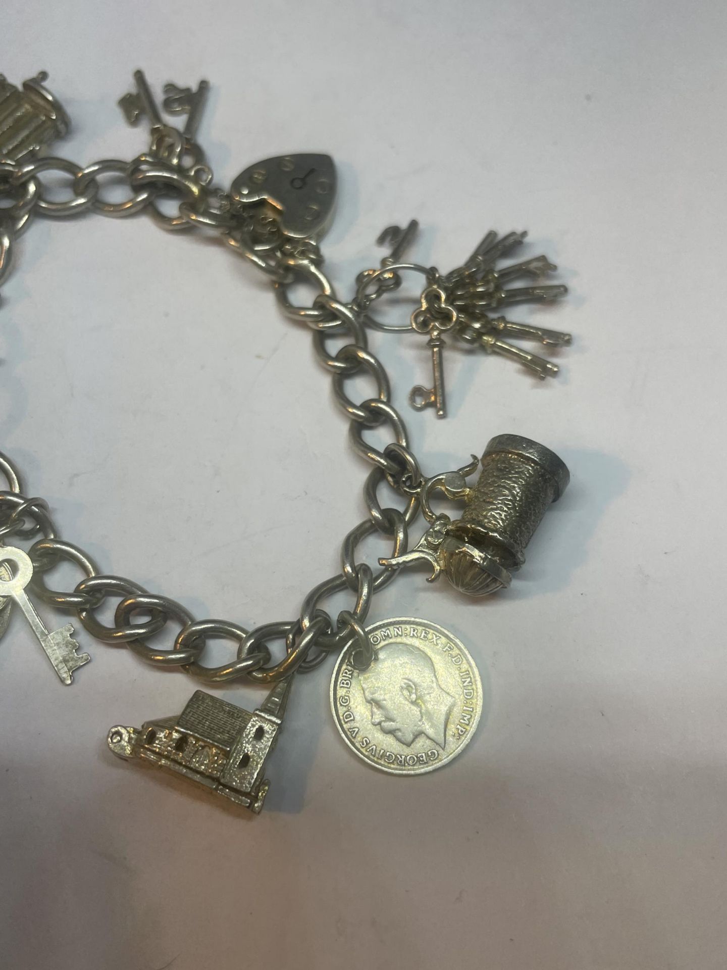 A SILVER CHARM BRACELET WITH ELEVEN CHARMS AND A HEART PADLOCK - Image 3 of 3