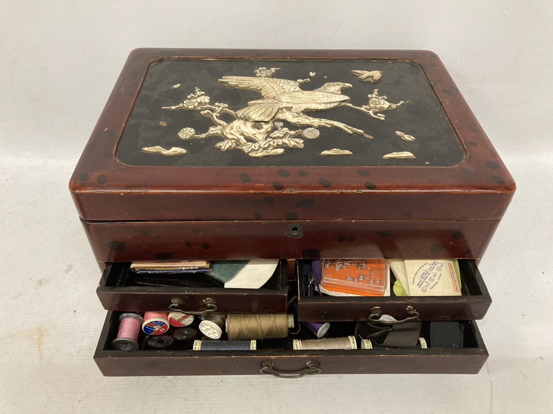 A JAPANESE LACQUERED SEWING BOX AND CONTENTS WITH BIRD DESIGN TOP AND INNER COMPARTMENTS AND LOWER