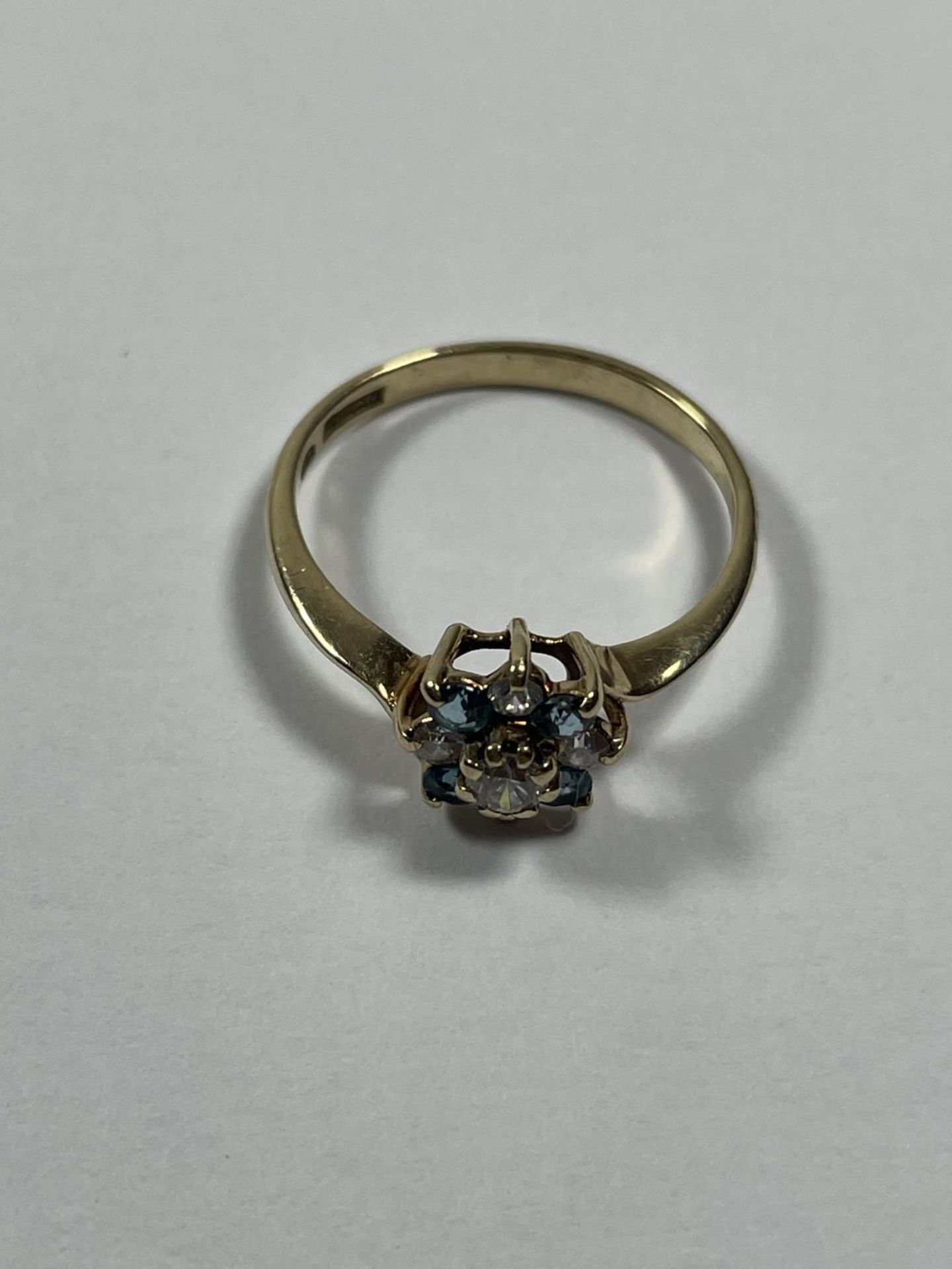 A 9 CARAT GOLD RING WITH BLUE TOPAZ AND CUBIC ZIRCONIAS IN A FLOWER DESIGN SIZE P