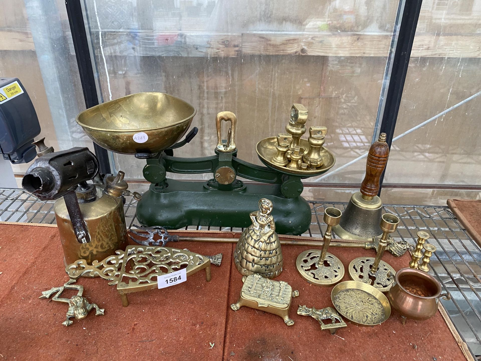 AN ASSORTMENT OF BRASS ITEMS TO INCLUDE SCALES AND WEIGHTS, TRIVET STANDS AND CANDLE STICKS ETC